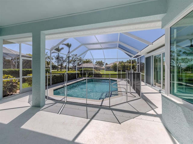 pool with glass enclosure and a patio area