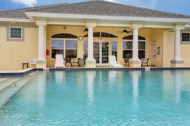 pool with french doors, a patio, and a ceiling fan