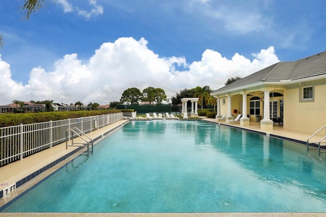 community pool featuring a patio and fence