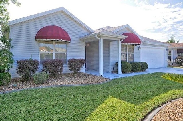 ranch-style house with a garage, concrete driveway, and a front yard