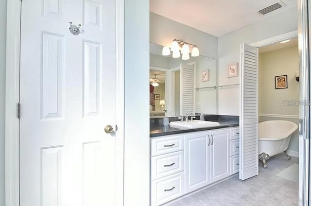 bathroom featuring vanity, a soaking tub, and visible vents