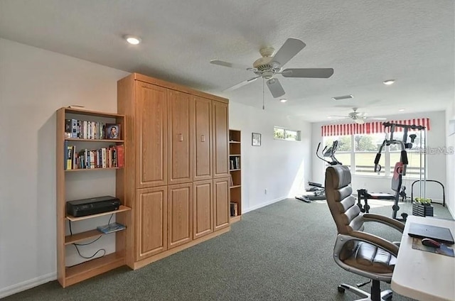 home office with visible vents, baseboards, ceiling fan, a textured ceiling, and dark colored carpet