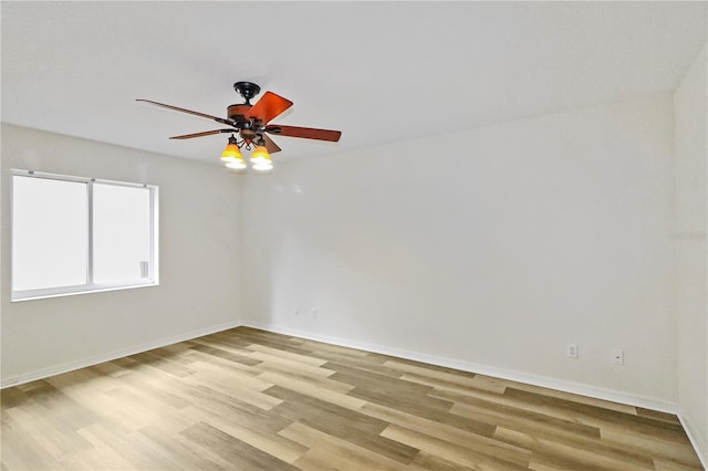 unfurnished room with baseboards, light wood-style floors, and a ceiling fan