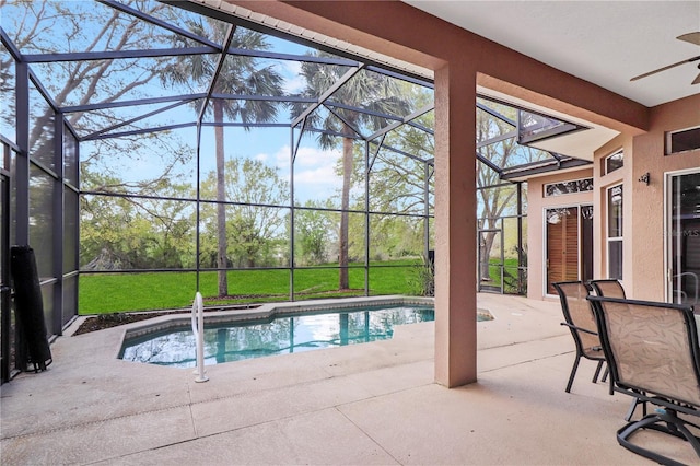 outdoor pool with a yard, glass enclosure, and a patio