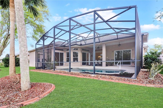 back of house featuring glass enclosure, a patio, a yard, and a ceiling fan