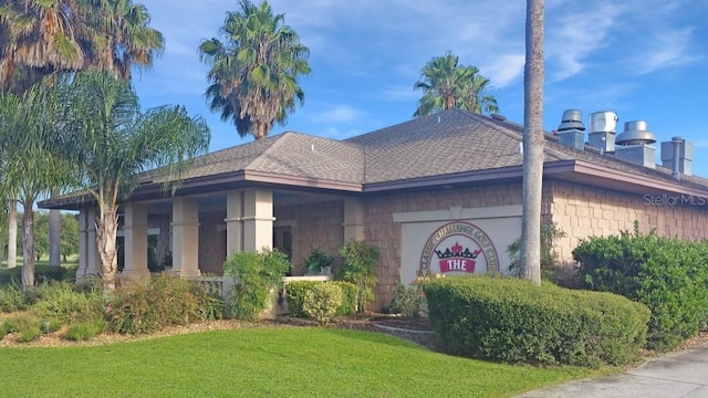 view of side of property with a lawn and a shingled roof