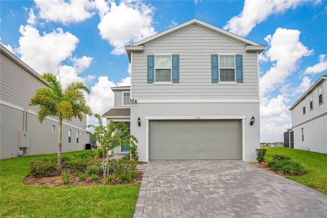 view of front of house featuring a garage, stucco siding, decorative driveway, and a front lawn