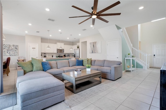 living room with recessed lighting, visible vents, light tile patterned flooring, and stairway