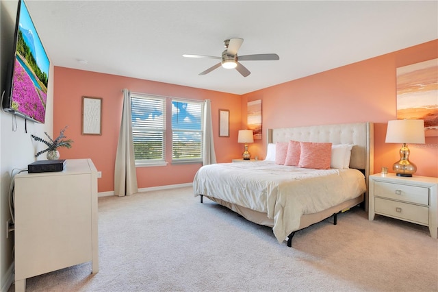 bedroom featuring light carpet, baseboards, and ceiling fan