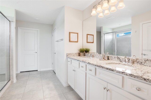 full bath with tile patterned flooring, a shower stall, and a sink