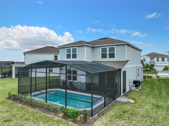 rear view of house with an outdoor pool, a yard, glass enclosure, and a shingled roof