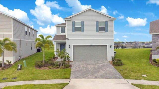 traditional-style house featuring stucco siding, an attached garage, decorative driveway, and a front yard