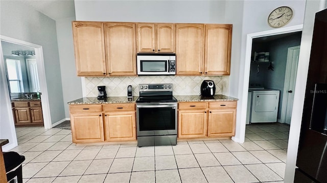 kitchen featuring light tile patterned floors, decorative backsplash, stainless steel appliances, and light stone counters