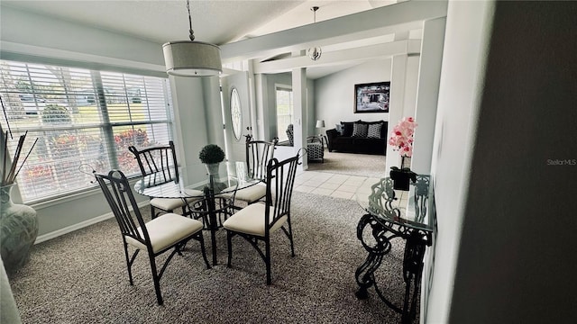 tiled dining area with baseboards, carpet, and vaulted ceiling