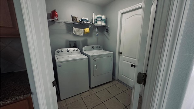 laundry room featuring light tile patterned floors, laundry area, and washing machine and dryer