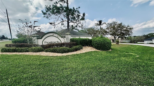 community / neighborhood sign featuring a lawn