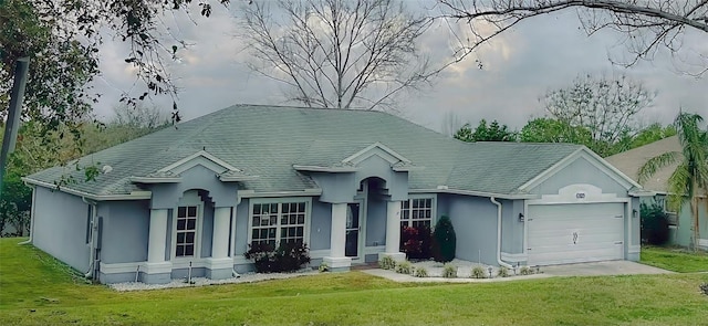 ranch-style house featuring a front yard, an attached garage, and stucco siding