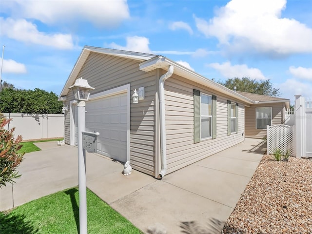 view of property exterior with an outdoor structure and fence