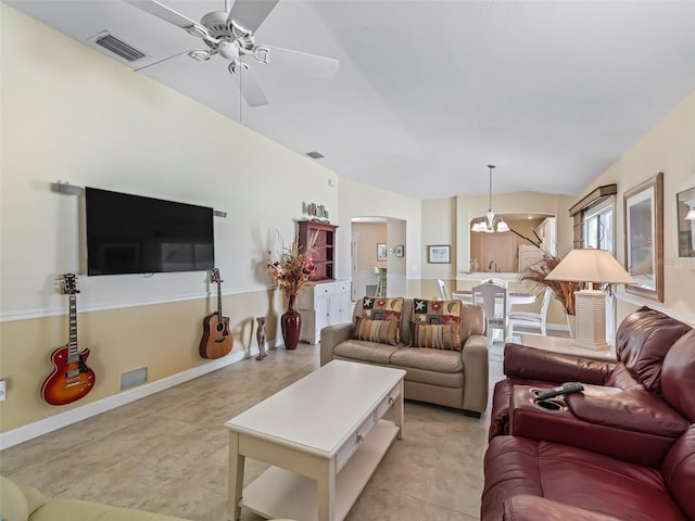 living area featuring visible vents, baseboards, ceiling fan, light tile patterned floors, and arched walkways