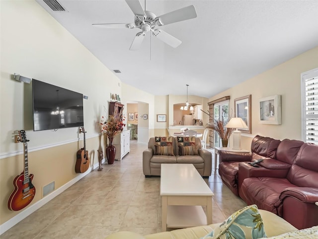 living area featuring light tile patterned floors, a ceiling fan, visible vents, lofted ceiling, and arched walkways