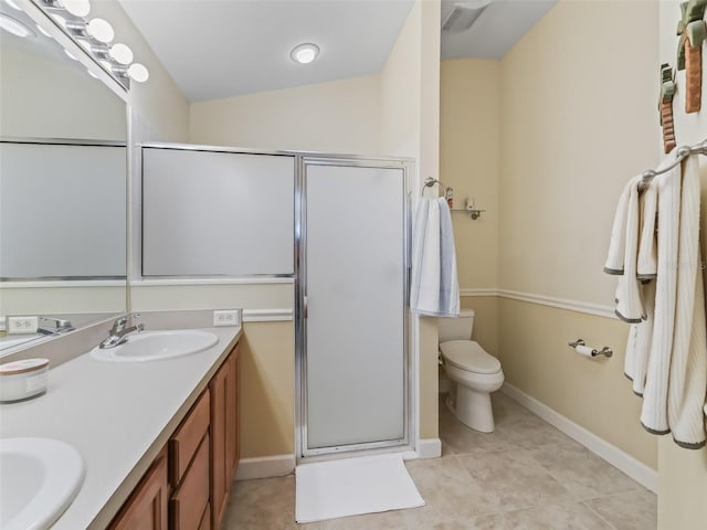 bathroom featuring double vanity, a stall shower, toilet, and a sink