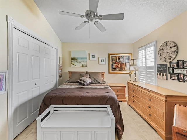 bedroom with light tile patterned flooring, a closet, and ceiling fan