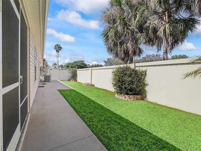 view of yard with central air condition unit, a patio, a fenced backyard, and a gate