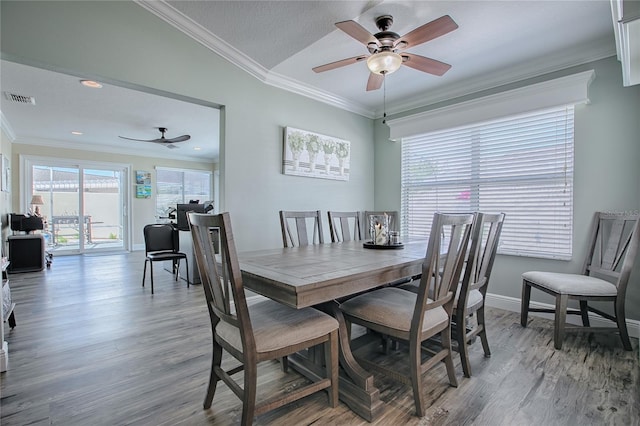 dining area with crown molding, visible vents, a ceiling fan, and wood finished floors