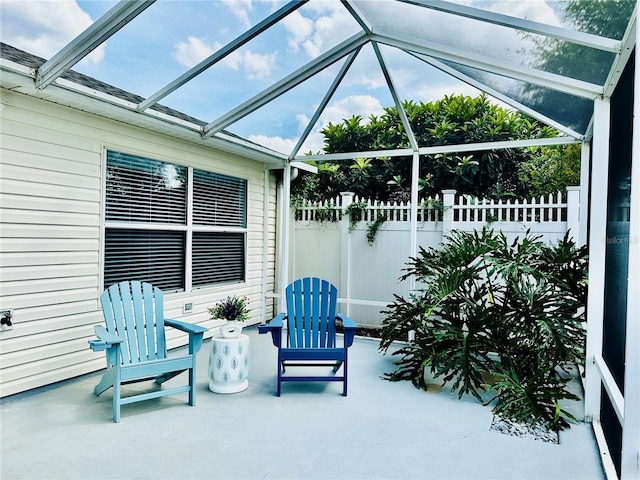 view of patio / terrace with a lanai and fence