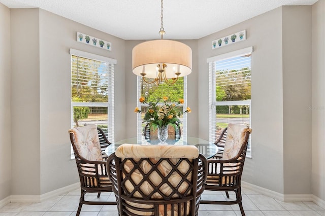 dining area featuring baseboards, an inviting chandelier, and light tile patterned flooring