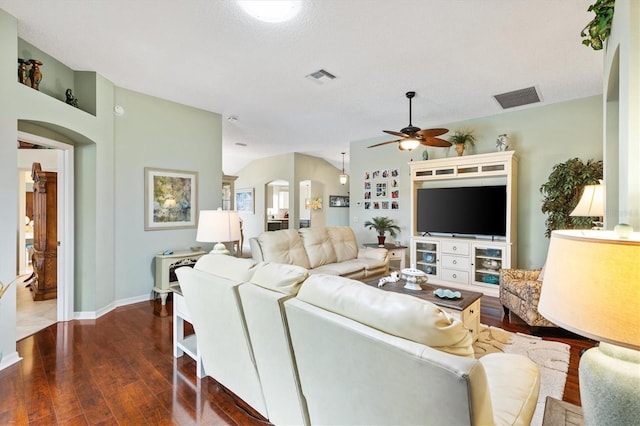 living area with visible vents, arched walkways, and wood finished floors