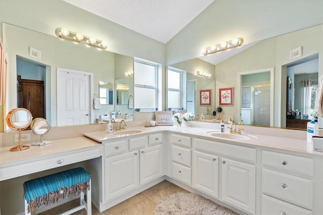 full bath featuring a sink, lofted ceiling, a shower stall, and tile patterned flooring