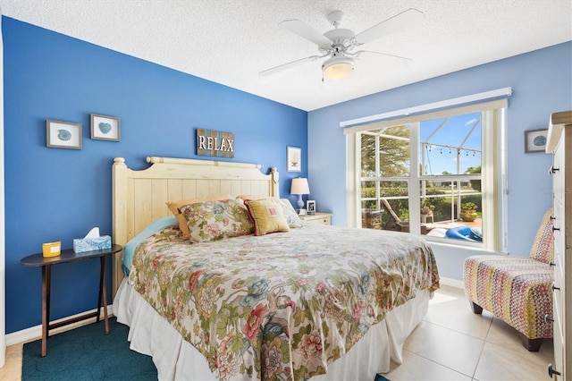 tiled bedroom featuring ceiling fan, baseboards, and a textured ceiling