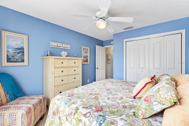 bedroom featuring visible vents, a textured ceiling, a closet, and ceiling fan