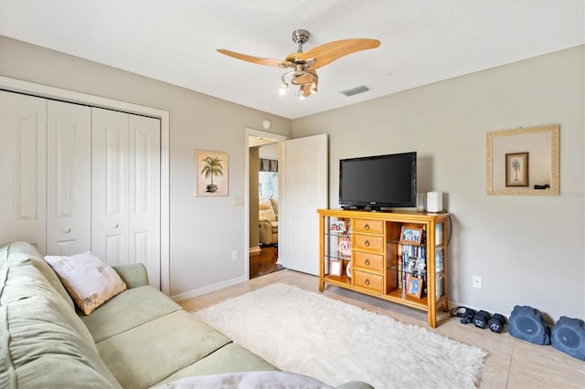 living area featuring visible vents, baseboards, and ceiling fan