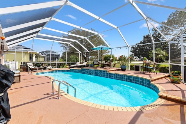 outdoor pool with a lanai and a patio area