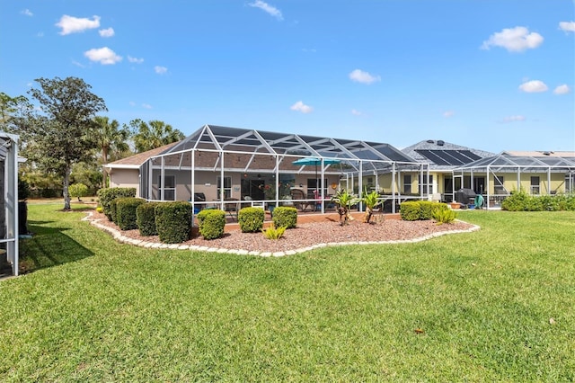 rear view of property with a lawn and glass enclosure