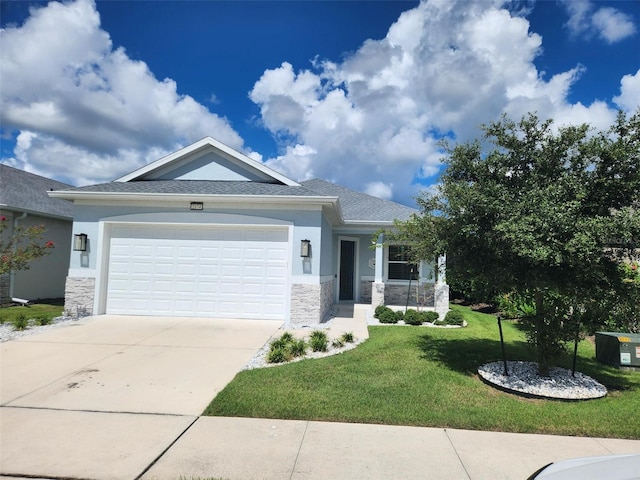 view of front of house featuring a front yard, an attached garage, stone siding, and stucco siding