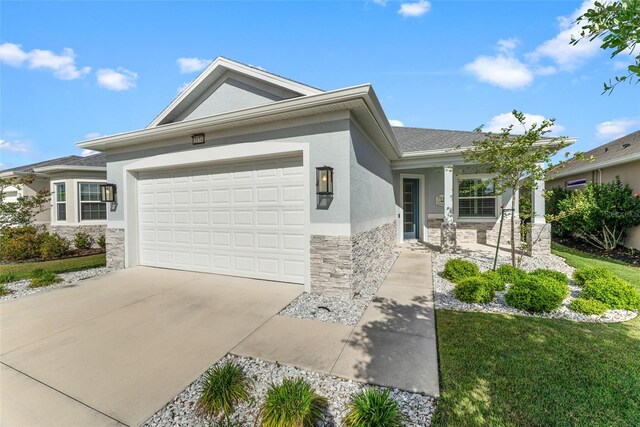 2174 Wallingford Loop, Mount Dora, FL 32757 - single story home with stone siding, stucco siding, an attached garage, and concrete driveway