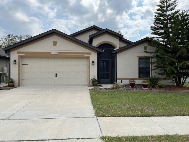 ranch-style house featuring stucco siding, an attached garage, concrete driveway, and a front lawn