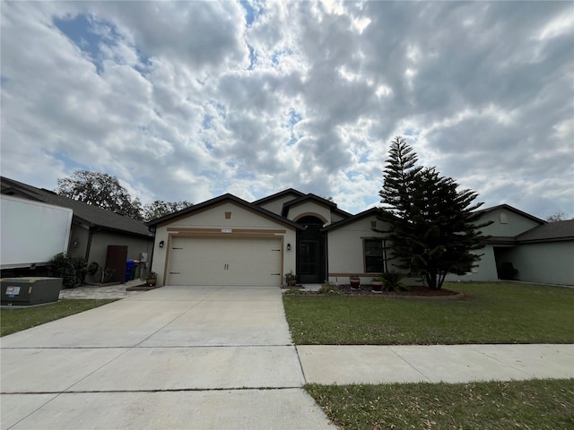 single story home featuring a garage, driveway, a front lawn, and stucco siding