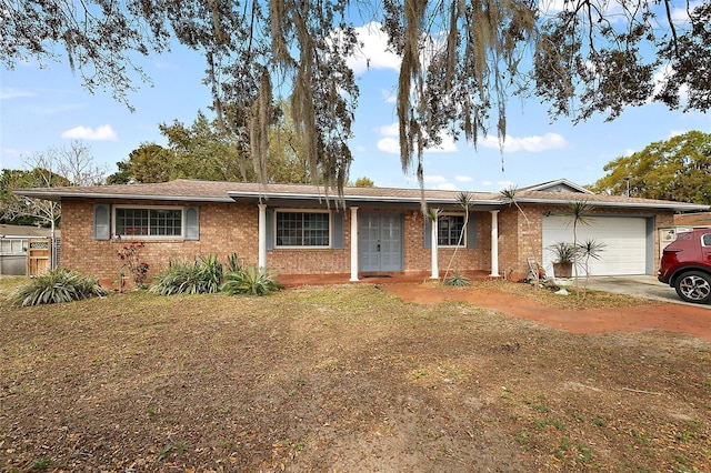 ranch-style home featuring brick siding, a front lawn, concrete driveway, and a garage