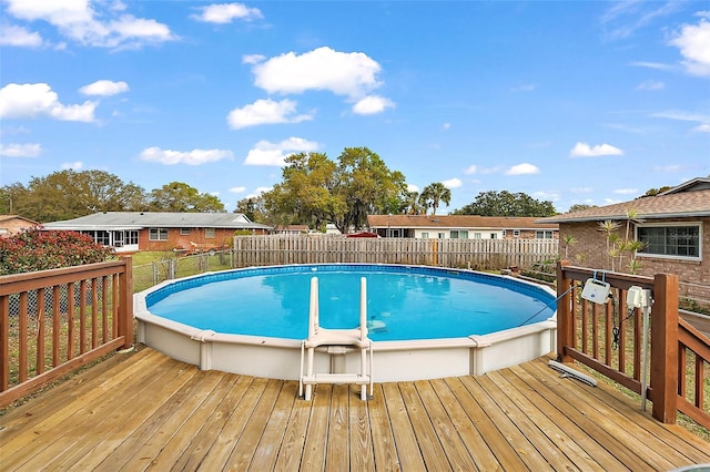 view of swimming pool with a fenced in pool, a fenced backyard, and a wooden deck