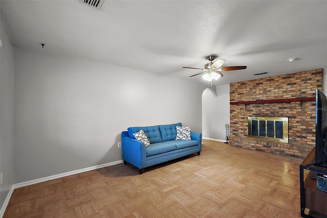 sitting room with visible vents, baseboards, a brick fireplace, and a ceiling fan