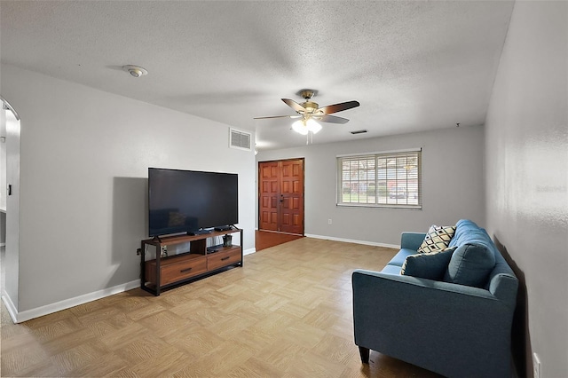 living room with visible vents, baseboards, arched walkways, ceiling fan, and a textured ceiling