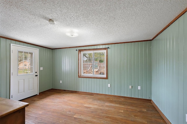 foyer featuring a textured ceiling, crown molding, and hardwood / wood-style flooring