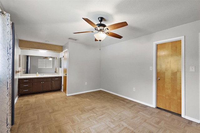 interior space with visible vents, ceiling fan, baseboards, and a sink