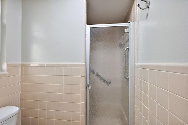 full bath featuring toilet, tile walls, and a shower stall