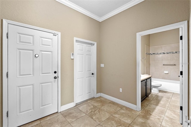 foyer featuring baseboards, light tile patterned flooring, and crown molding