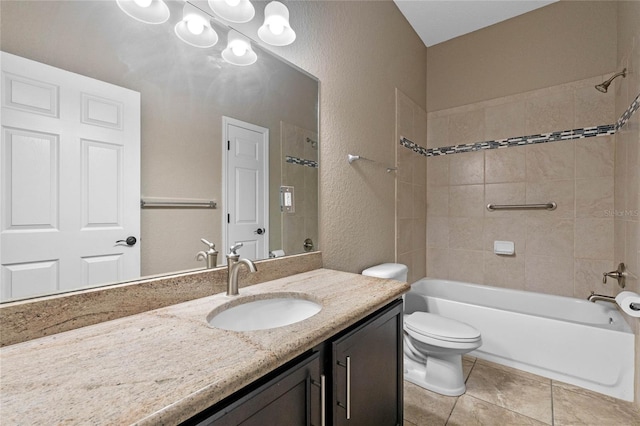 full bath with tile patterned floors, toilet, vanity, shower / bathtub combination, and a textured wall